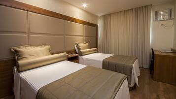 Une chambre d’hôtel avec deux lits, un bureau et une chaise.