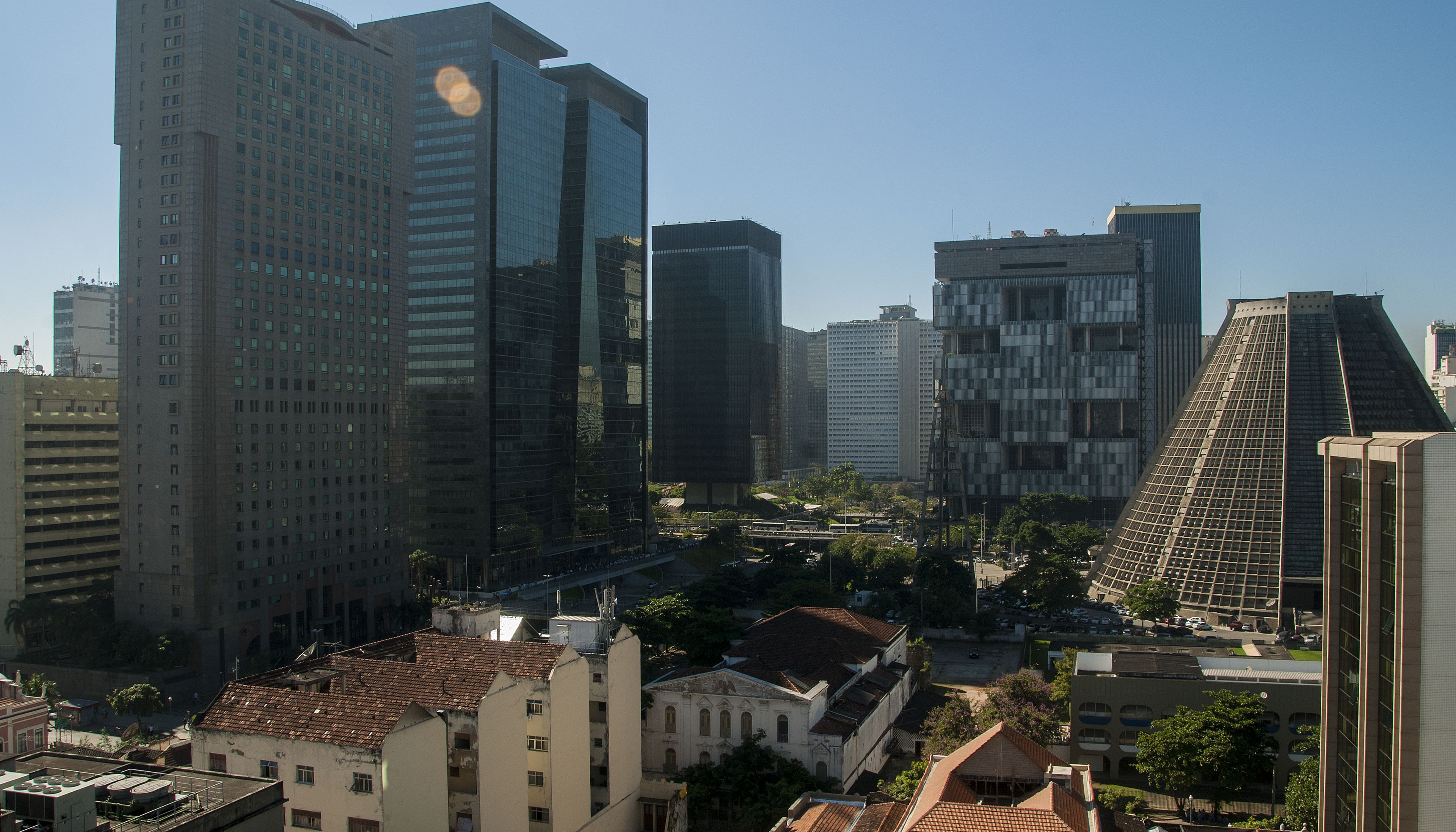 Un paisaje urbano con edificios modernos altos y construcciones más antiguas y de menor tamaño.