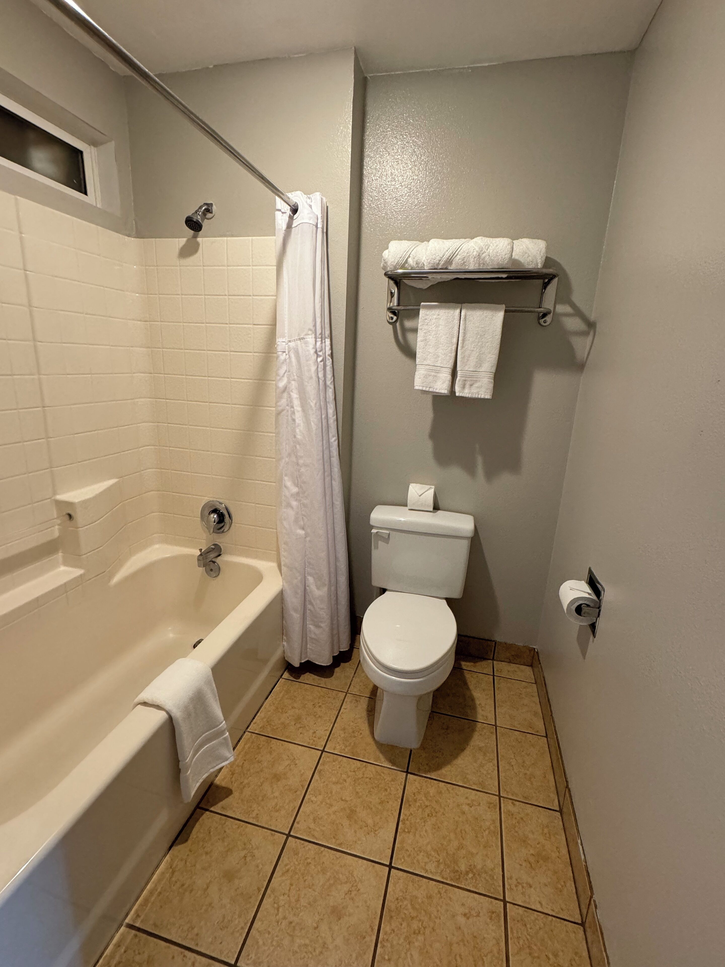 Une salle de bain équipée d’une baignoire, de toilettes et d’un porte-serviettes avec des serviettes.