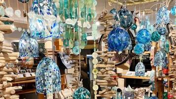 A variety of glass ornaments and decorations hanging from the ceiling in a store.