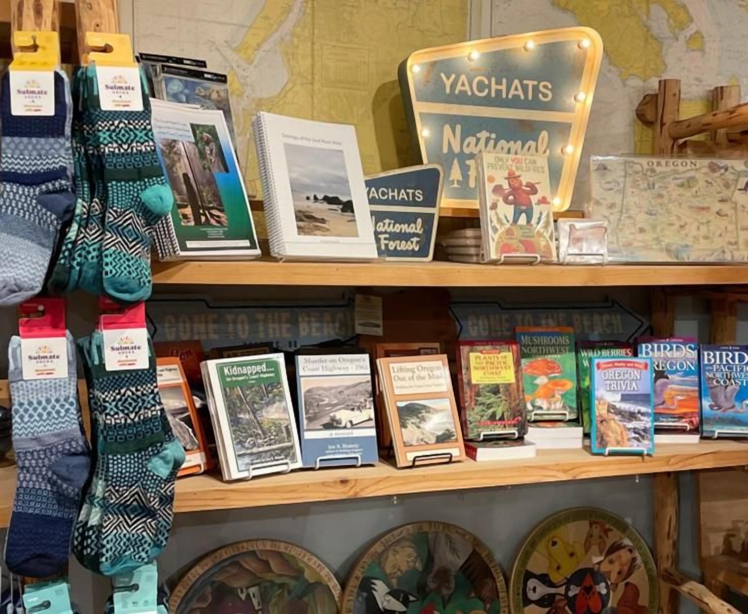 Eine Präsentation aus Socken, Büchern und einem Schild über den Yachats National Forest.