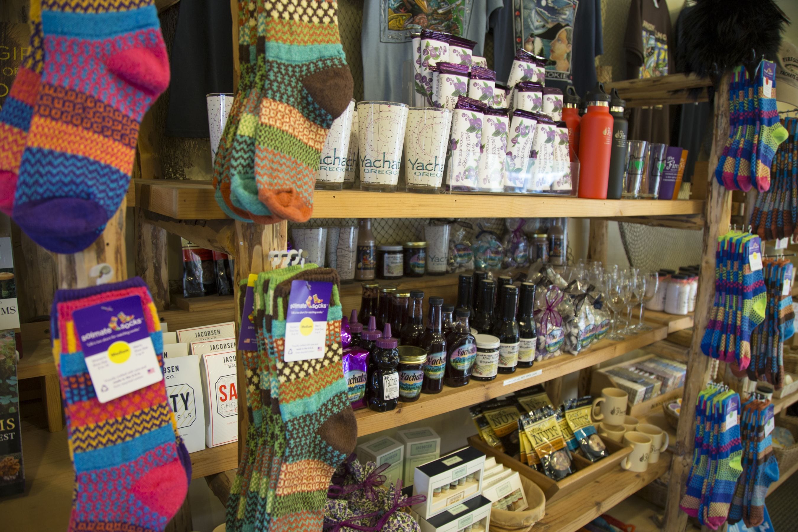 A store with shelves stocked with various items including socks, candles, and bottles.