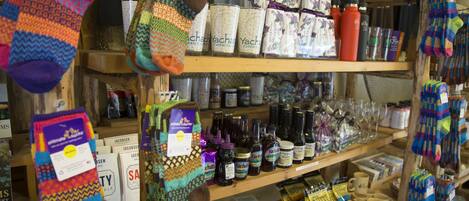 A store with shelves stocked with various items including socks, candles, and bottles.