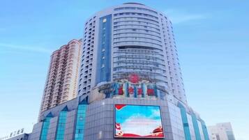 A high-rise building with a prominent billboard and a large entrance.