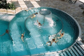 A circular pool with a central water feature and people swimming. - JUFA Hotel Kempten (Kempten)