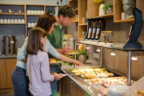 A buffet setup with various food items and a selection of wine bottles. - JUFA Hotel Kempten (Kempten)