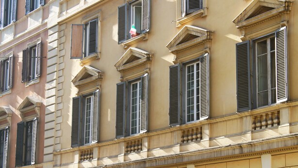 A multi-story building with classical architecture, featuring symmetrical window designs and decorative moldings. - Al Passetto St. Peter's bike (Rome)