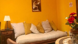 A room with a sofa, a lamp, a painting, and a no-smoking sign. - Al Passetto St. Peter's bike (Rome)