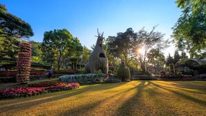 A garden with statues, pathways, and various plants. - Doi Tung Lodge (Mae Fa Luang)
