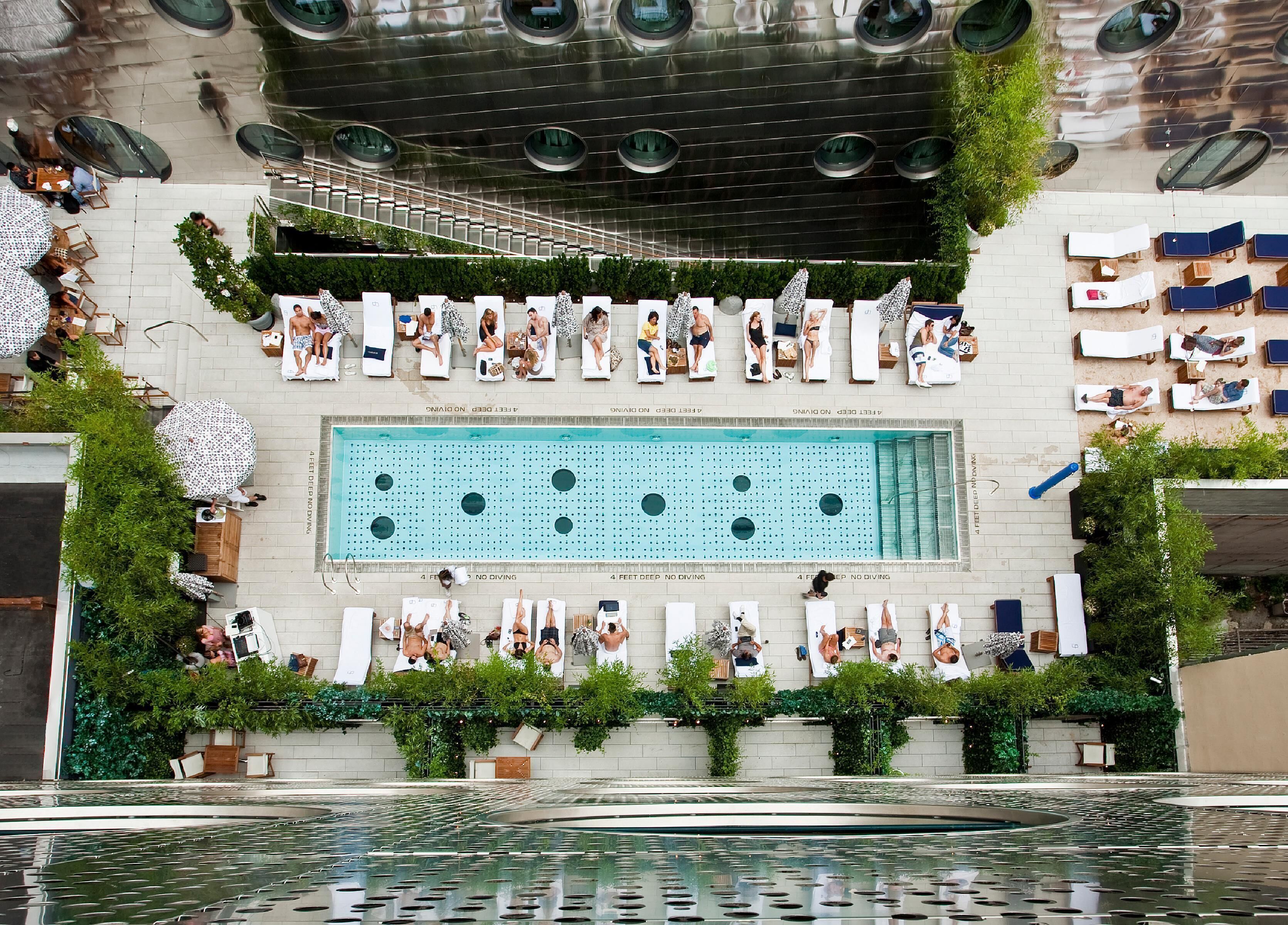 A rooftop pool area with lounge chairs and a swimming pool.