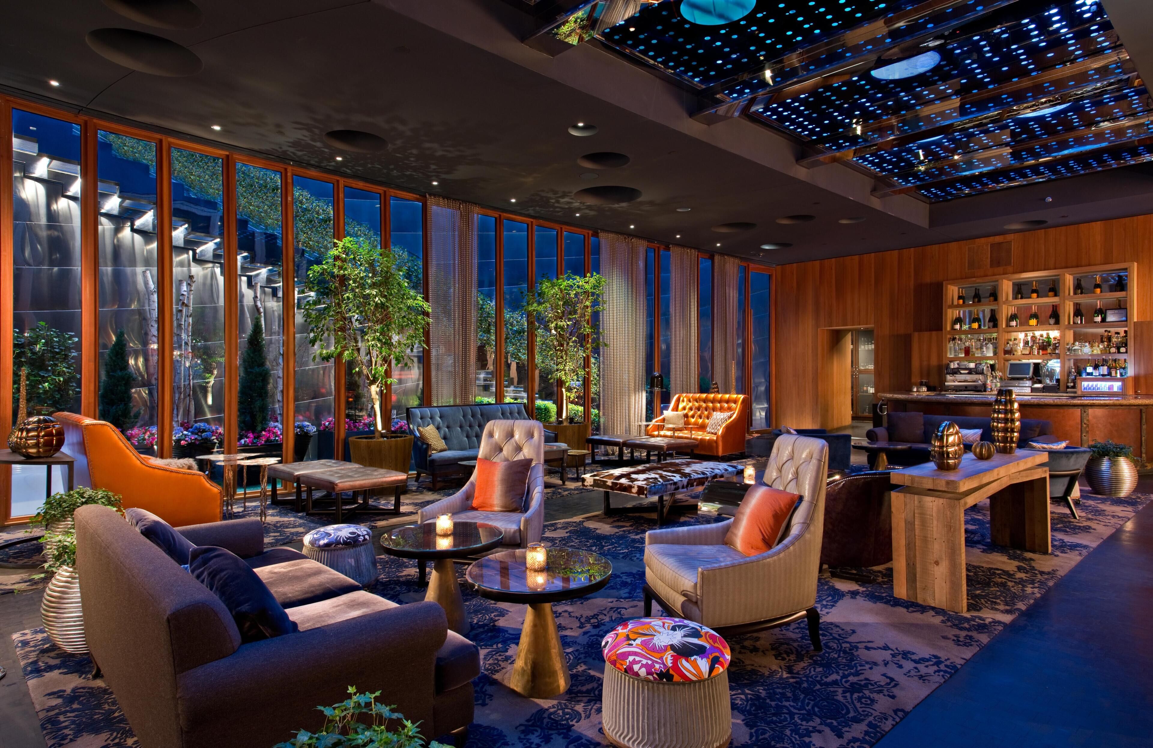 Een moderne loungehoek met zitplaatsen, een bar en grote ramen.