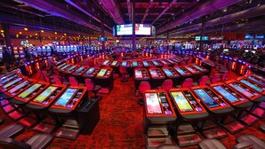 Un gran casino con varias mesas de juego y sillas dispuestas en círculo.