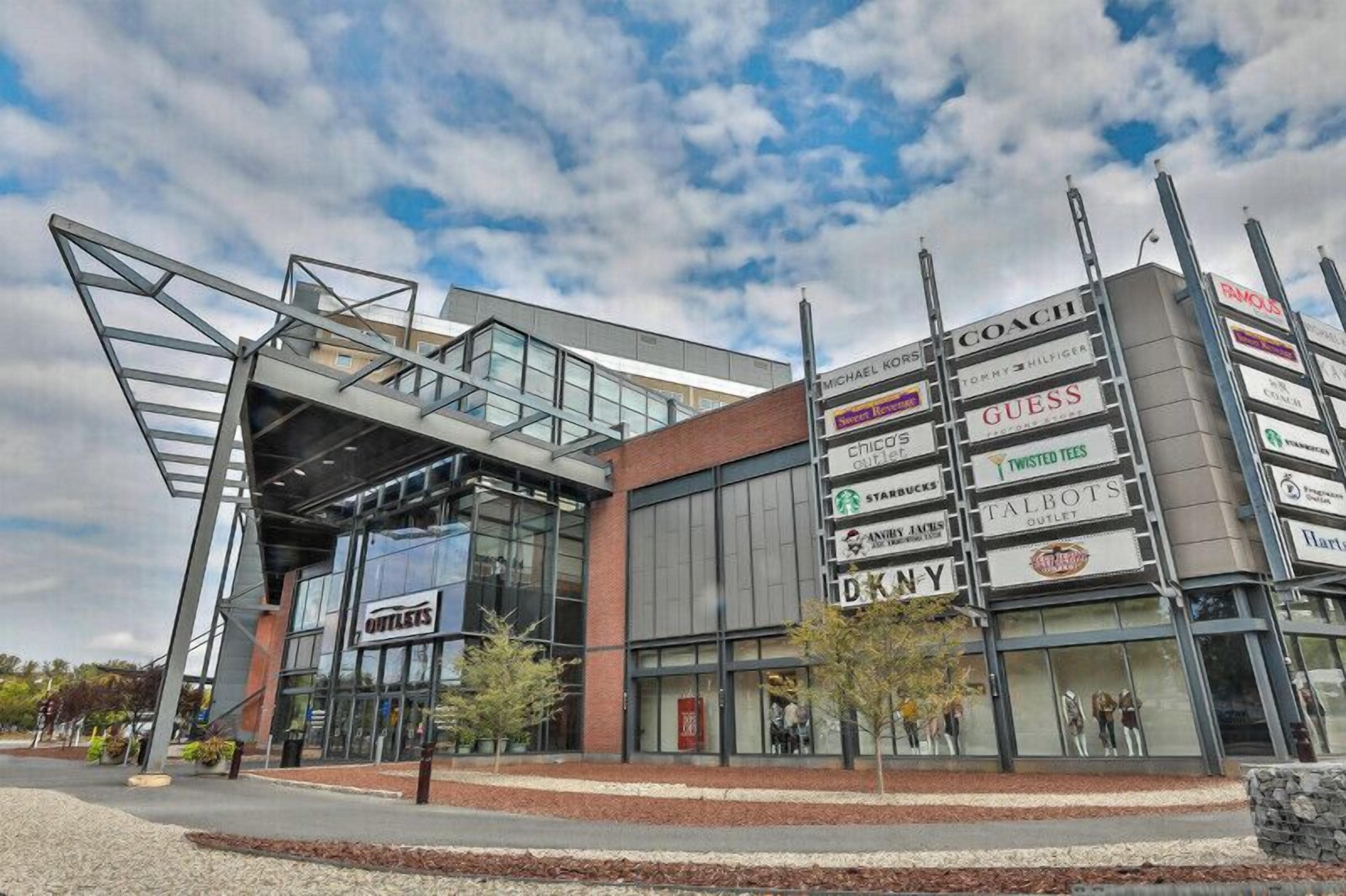A modern building with a glass facade and multiple commercial signs.