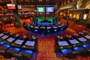 Un salón de casino con varias mesas de juego y una zona de bufé.