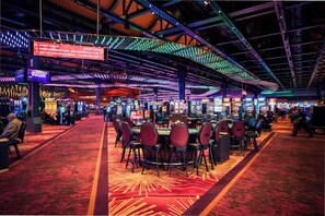 Een casino met verschillende speeltafels en een rode loper.