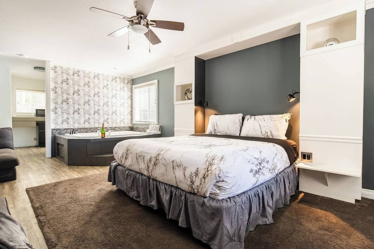 Une chambre avec un grand lit, un bureau intégré et une fenêtre.