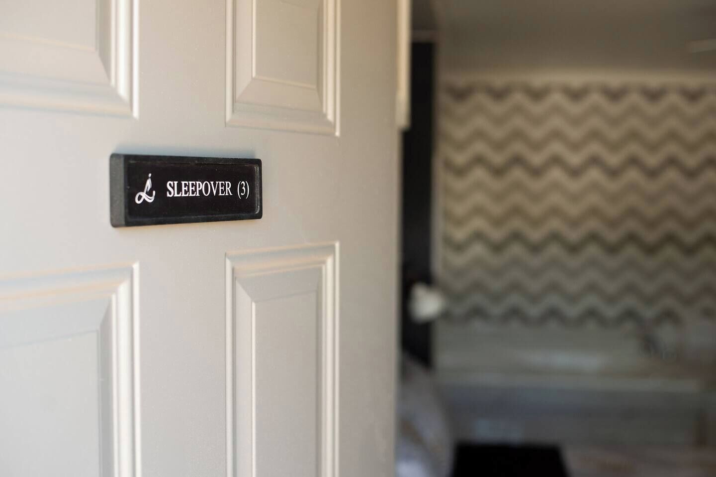 A door with a sign reading "SLEEPOVER (3)".