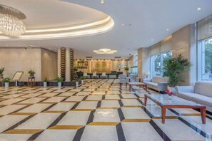 A hotel lobby with a check-in desk, seating area, and a patterned floor. - Harbour Oriental Hotel（Beilun Changjiang Road Store） (Ningbo)