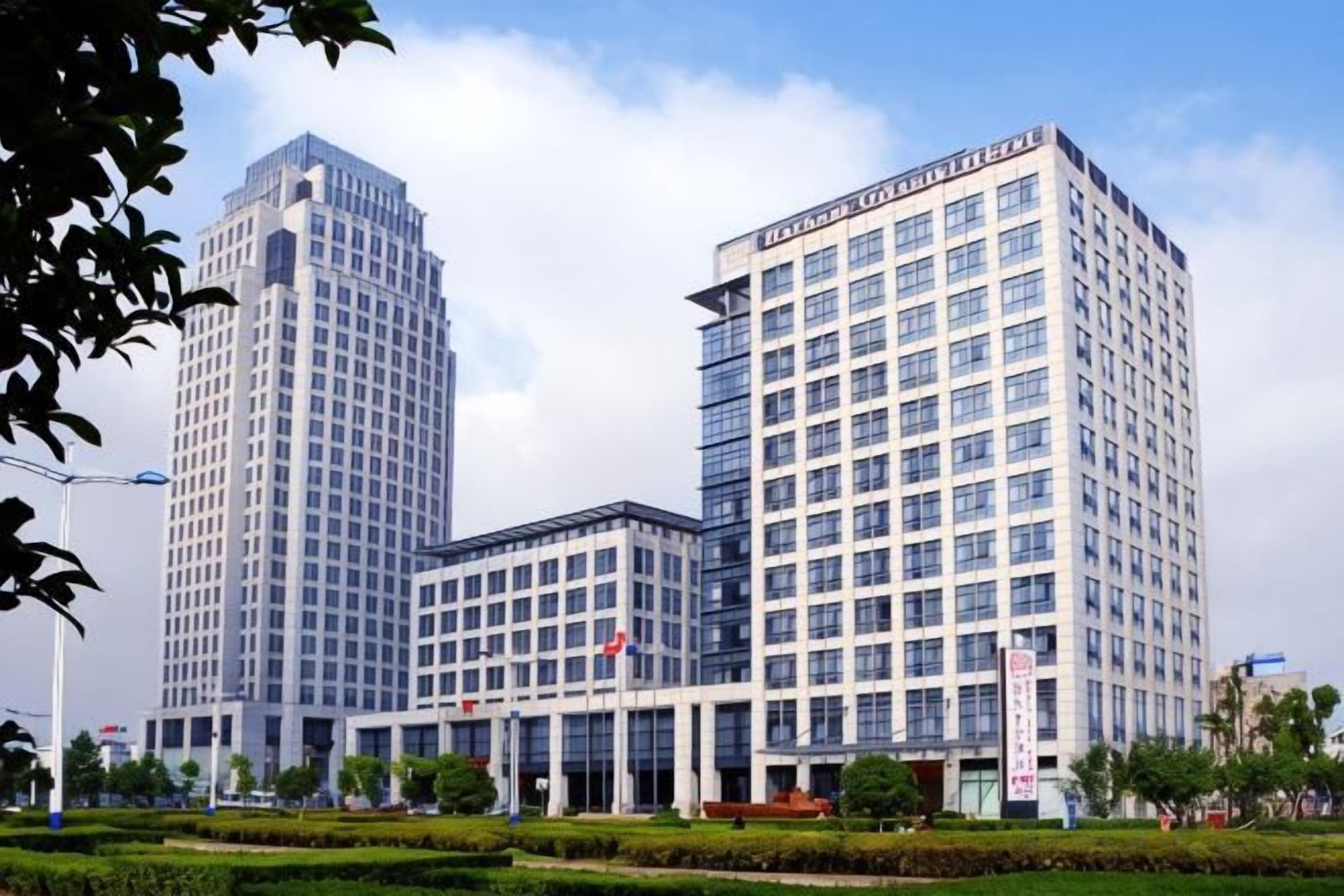 Un edificio moderno con varios pisos, amplias ventanas y una entrada destacada.