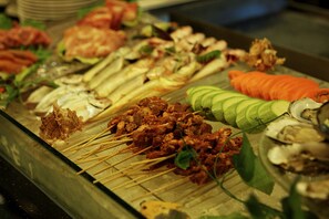 Variedad de carnes y verduras ensartadas en una bandeja.