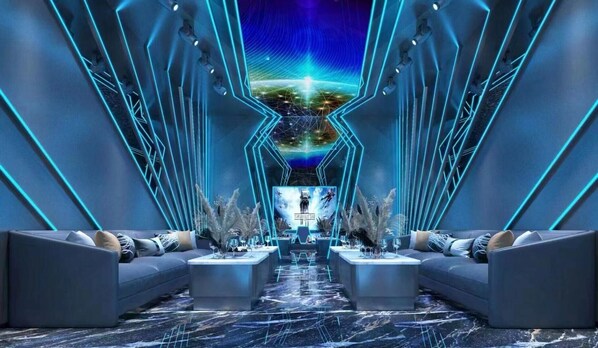 Un salón futurista con una mesa central, sofás y un techo iluminado con neón.