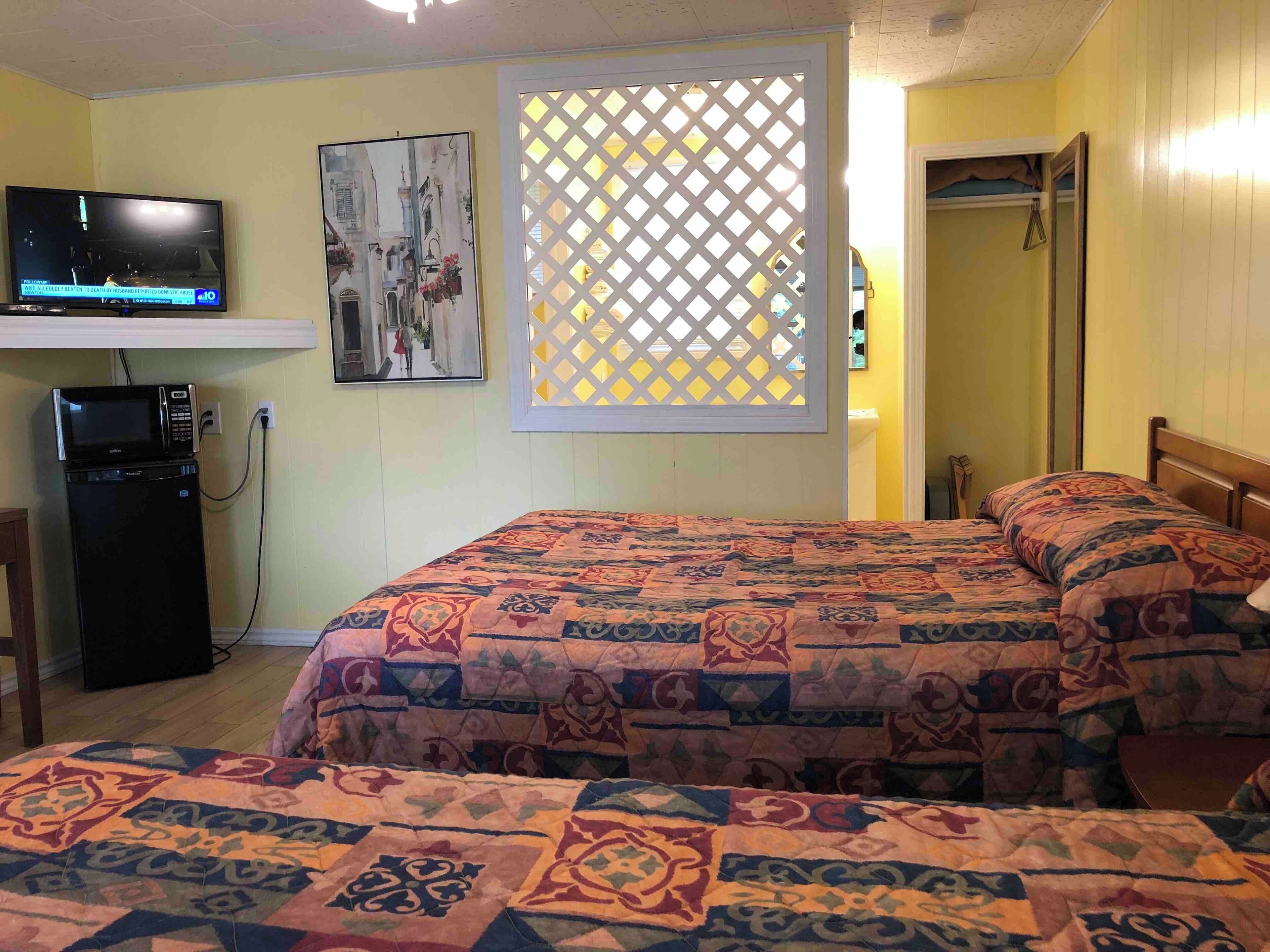 Une chambre d’hôtel équipée d’un lit, d’une télévision et d’une petite kitchenette.