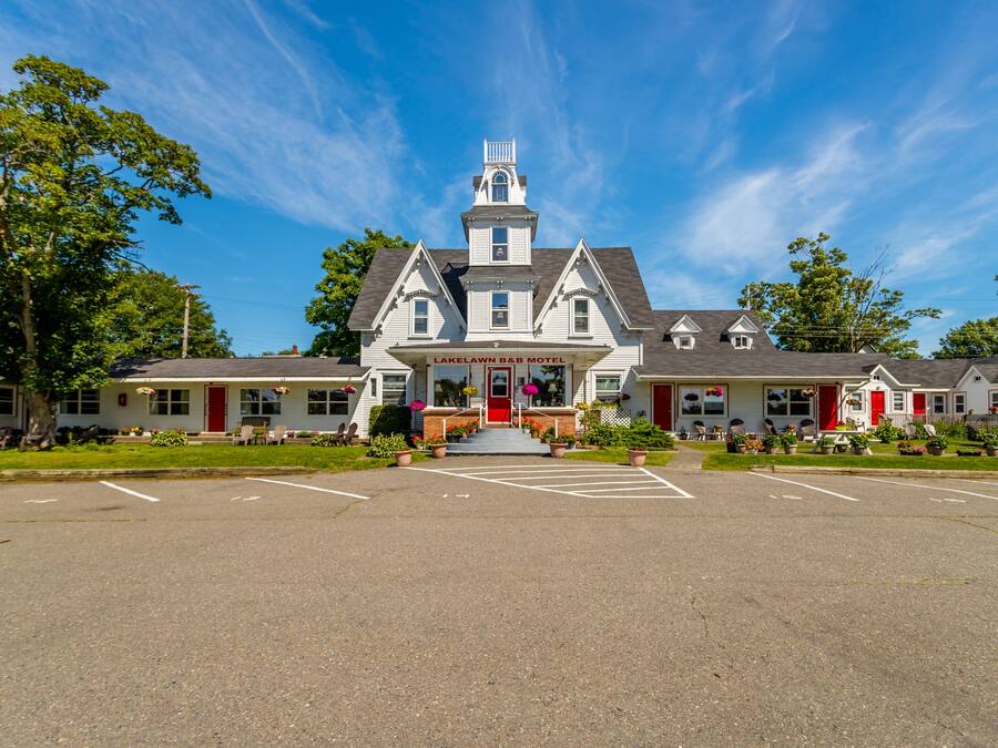 A two-story building with a central entrance, a red door, and a sign reading "Lakeland B&B Motel."