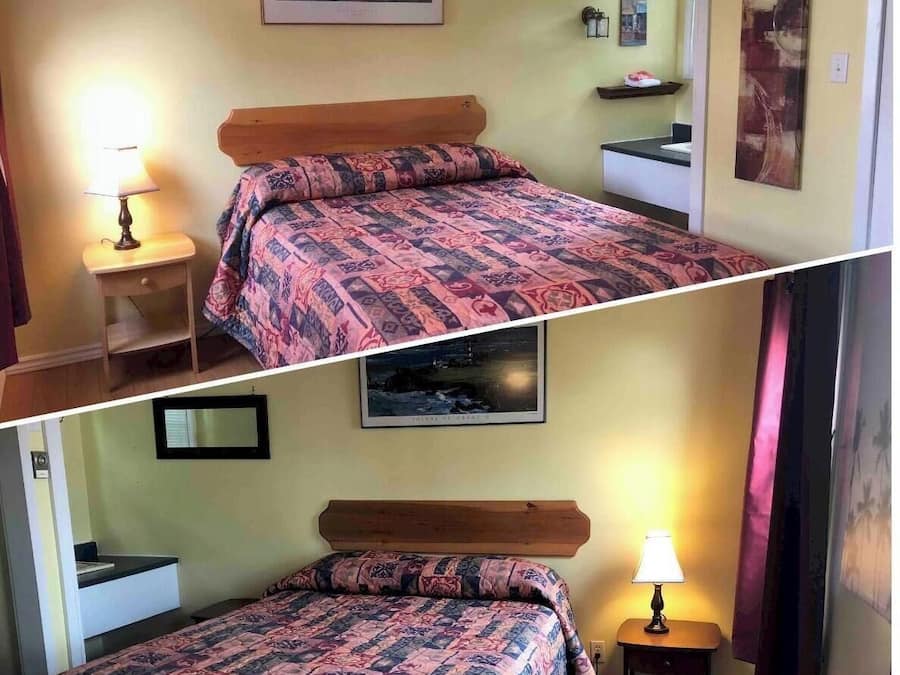 A bedroom with a bed, bedside table, lamp, and a small shelf with a picture.
