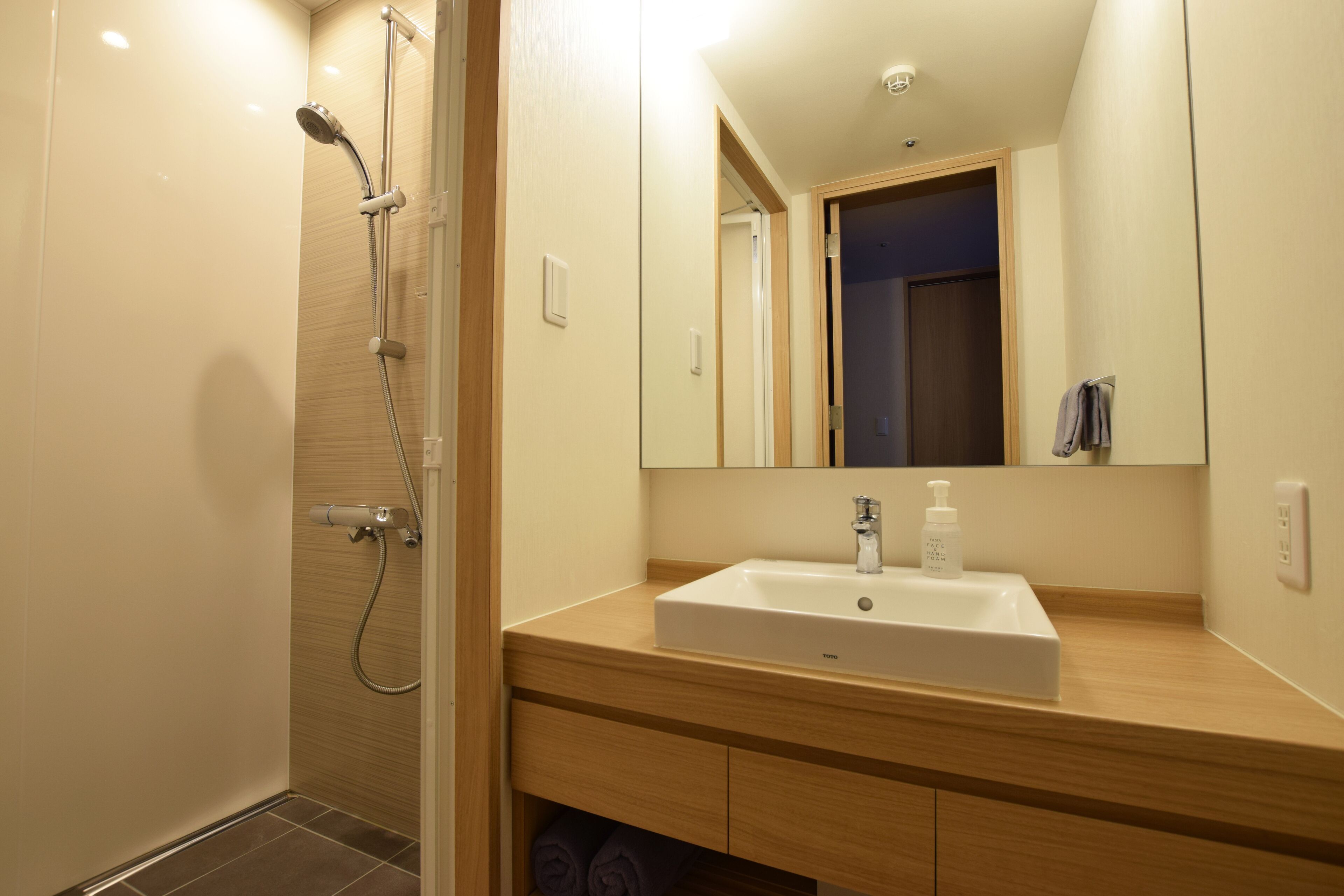 Un baño moderno con ducha, lavabo y espejo.