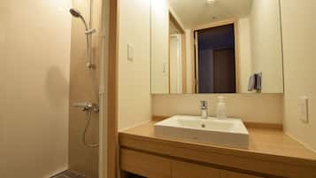 Un baño moderno con ducha, lavabo y espejo.