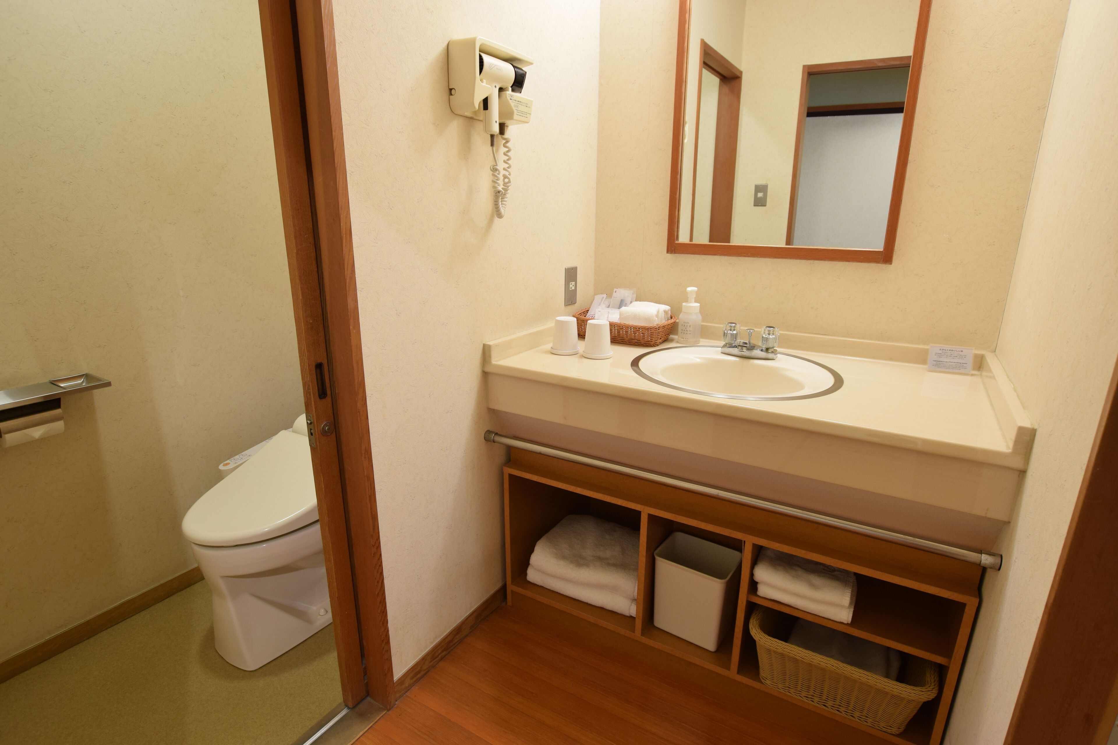 Un baño con inodoro, lavabo y espejo.