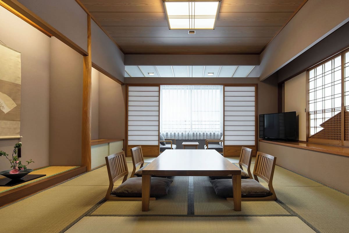 A traditional Japanese-style room with tatami flooring, a low table, and shoji screens.