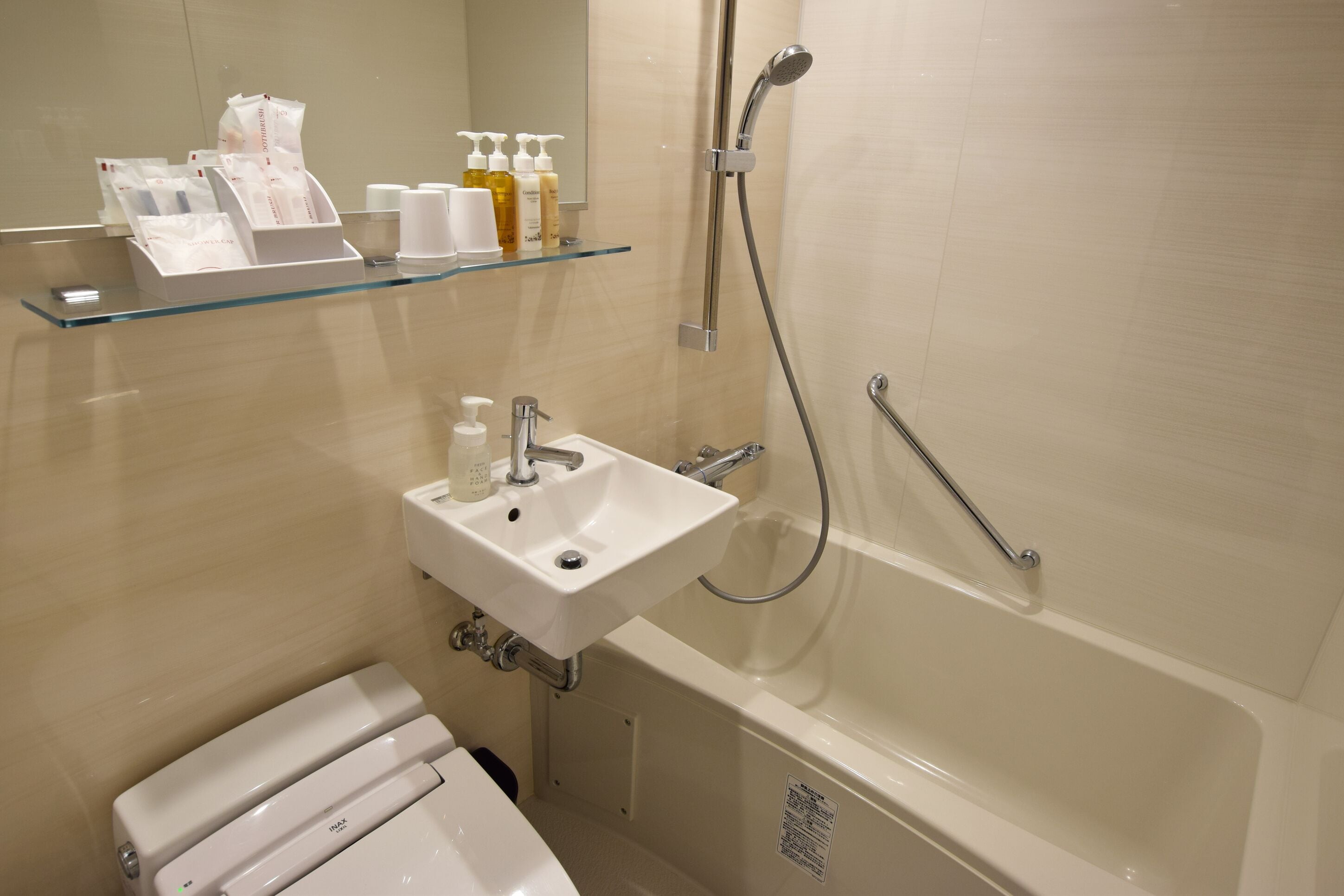 Ein modernes Badezimmer mit einer Glasablage für Toilettenartikel, einem Waschbecken und einer Badewanne.