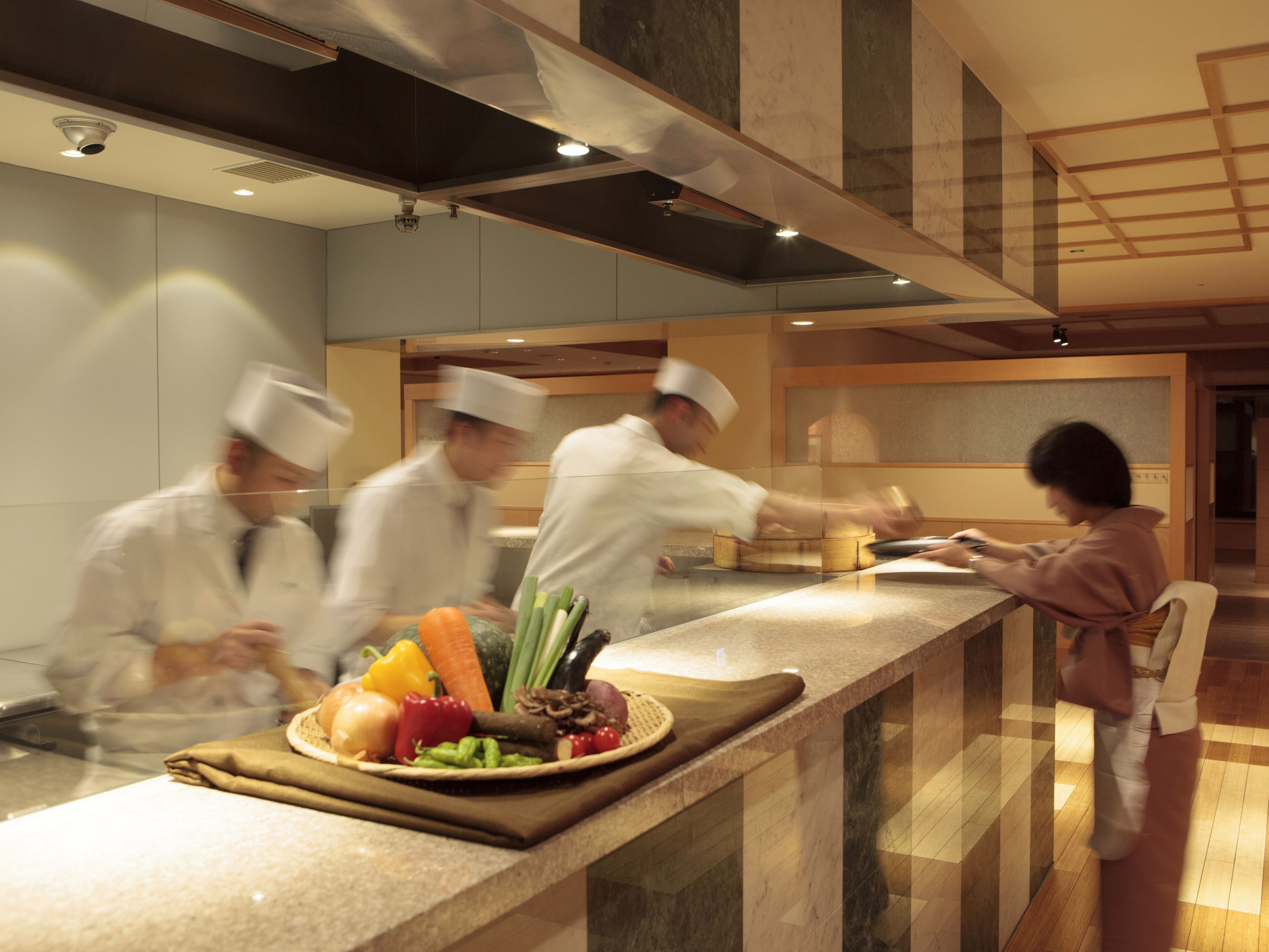 A modern kitchen with chefs preparing food.