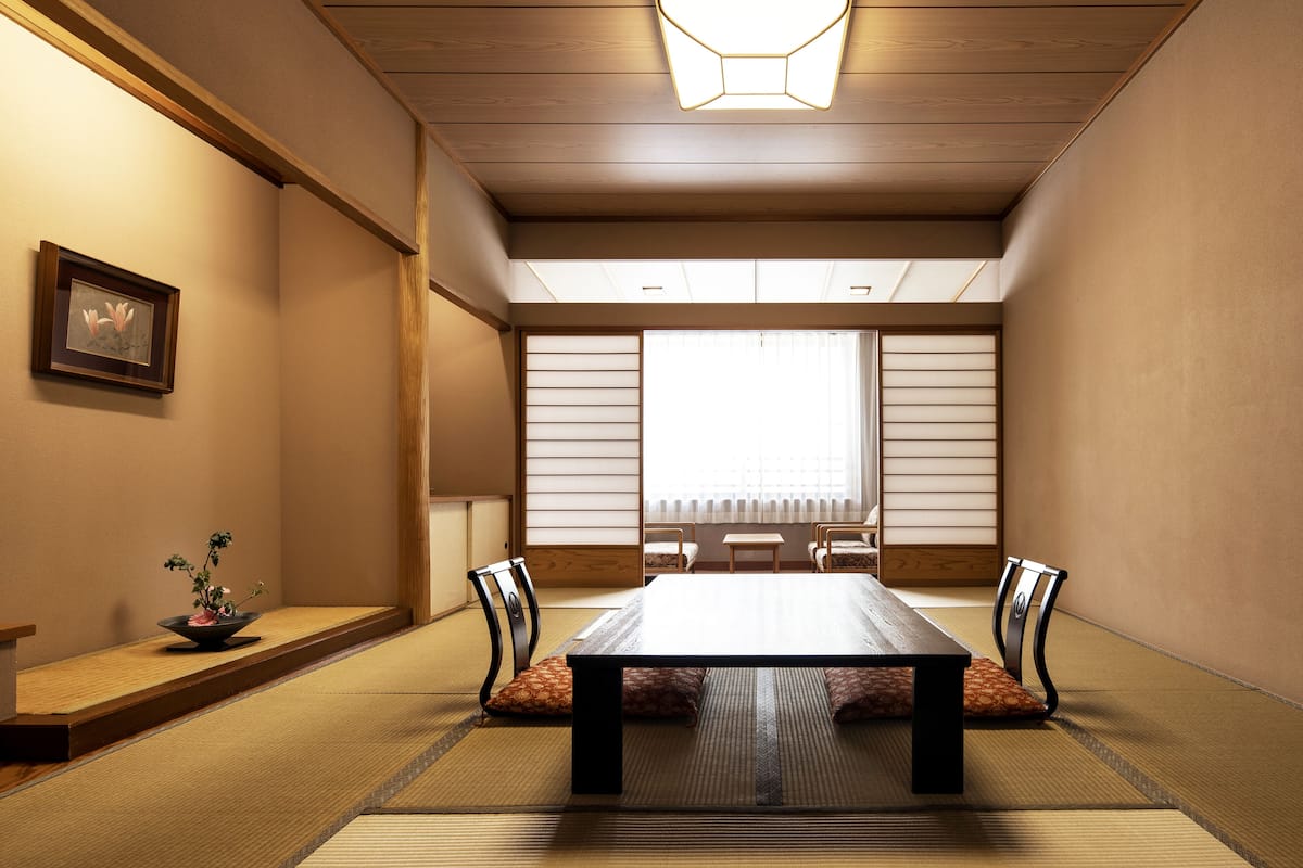 A traditional Japanese room with tatami flooring, a low table, and shoji screens.