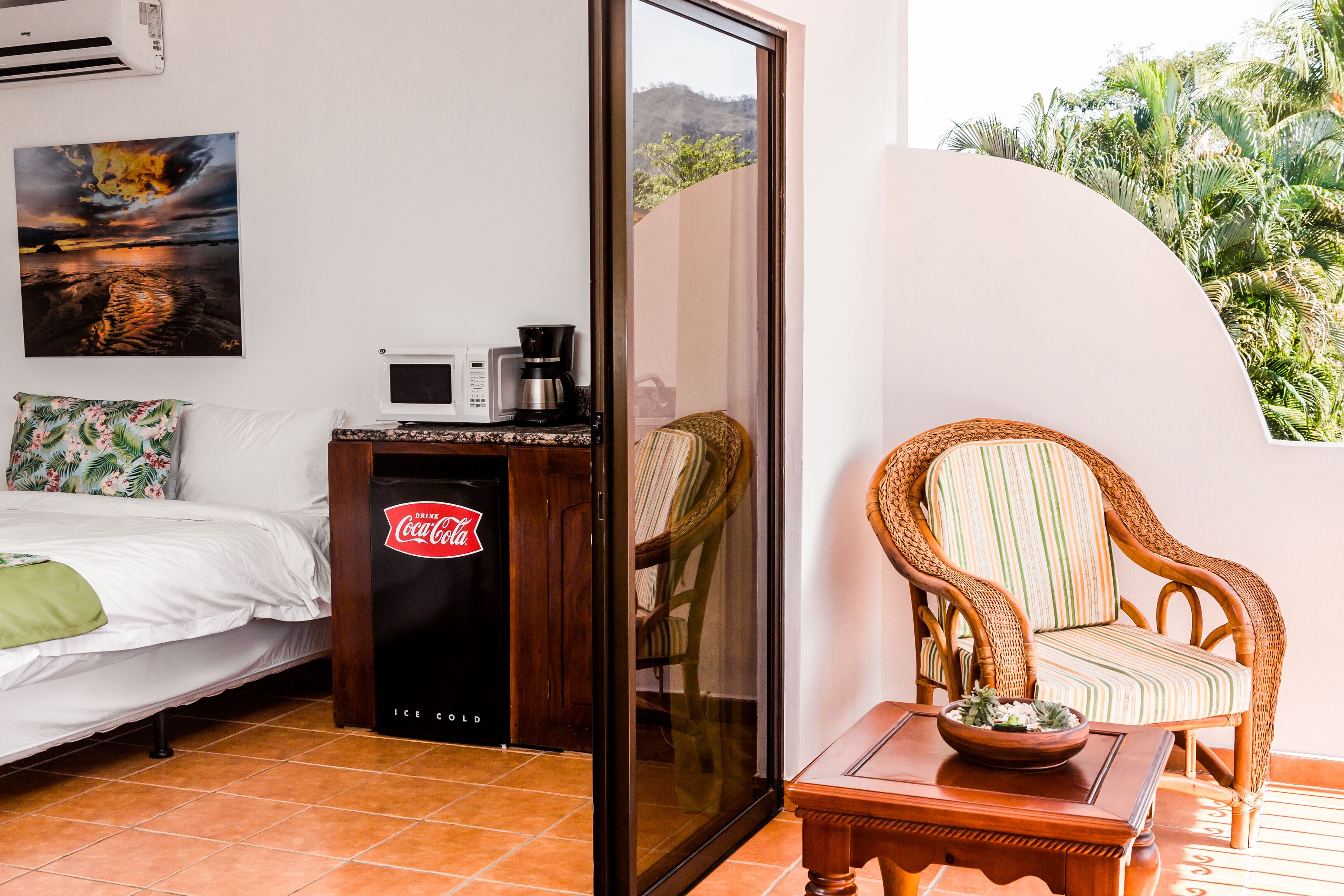 Une chambre avec un lit, une machine à café et un réfrigérateur.
