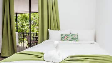 Relax in comfort with a large bed and serene views of lush greenery from the balcony.