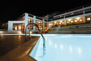 Una piscina al aire libre, sombrillas, tumbonas