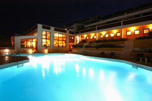 Una piscina al aire libre, sombrillas, tumbonas