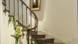 Un escalier en bois avec un vase de fleurs posé sur la plateforme.