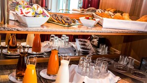 A breakfast buffet with various food items, beverages, and condiments. - Hotel Corvinus (Vienna)