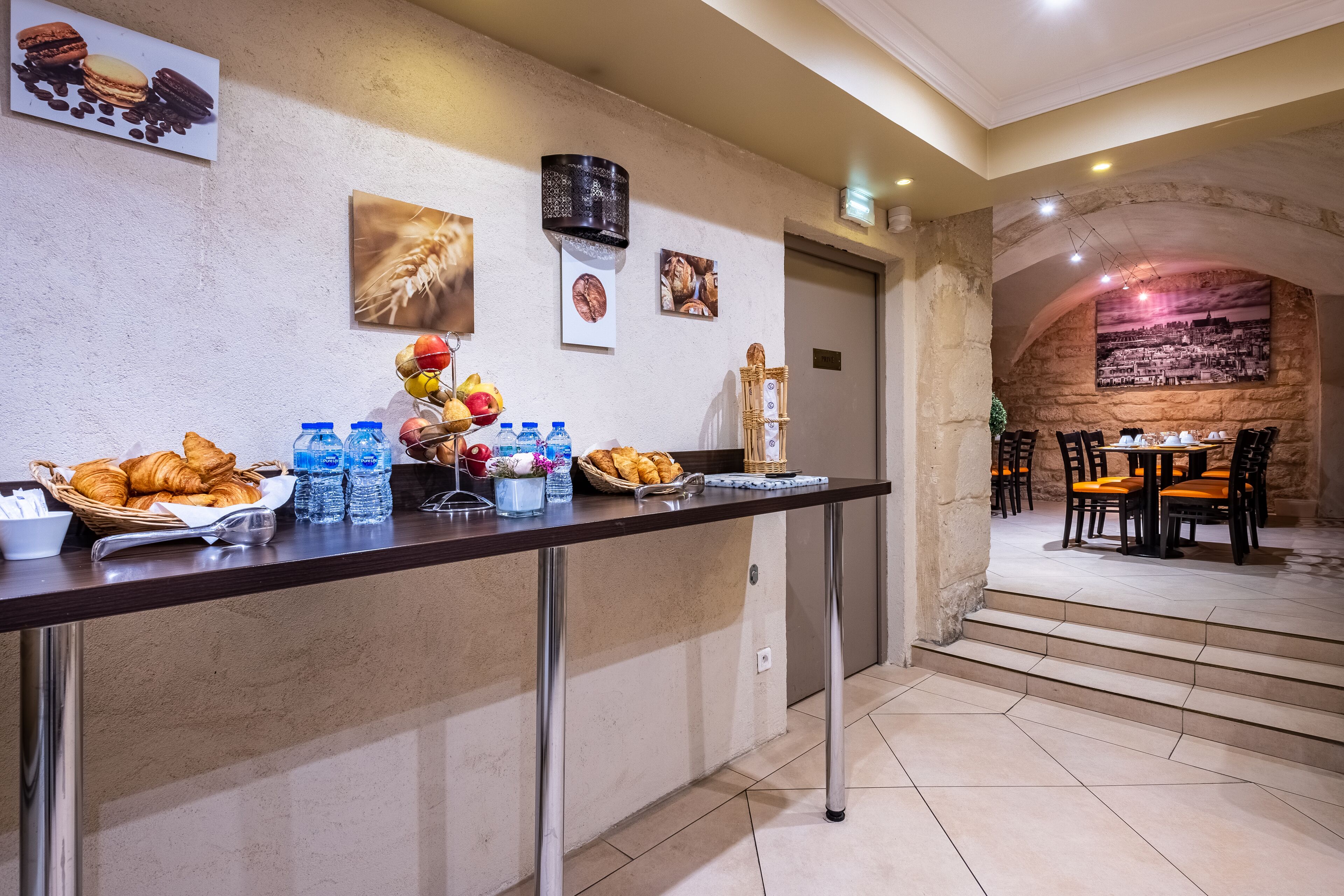 A breakfast buffet with croissants, pastries, and water bottles.