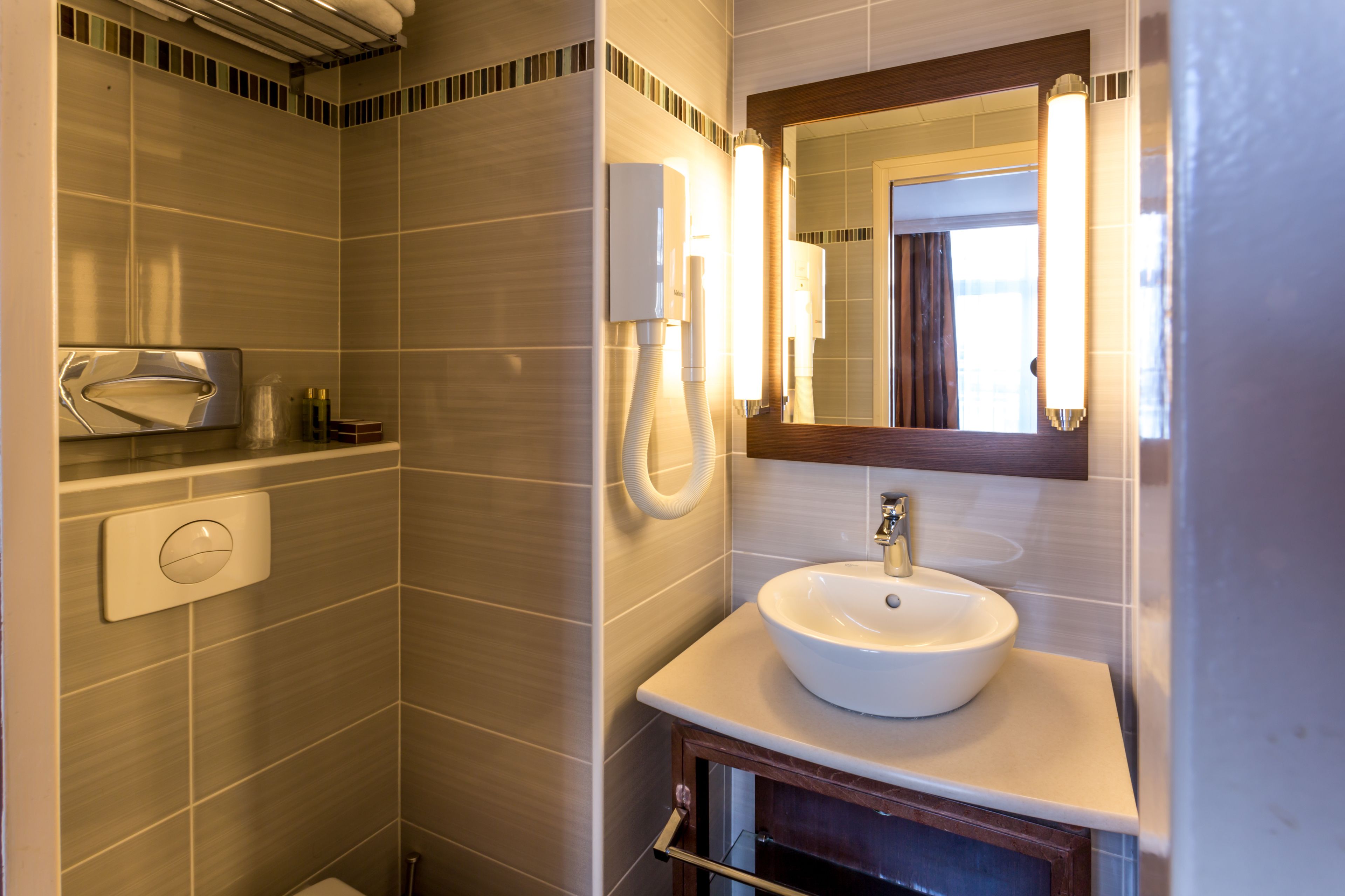 A modern bathroom with a large sink, a mirror, and a shower.