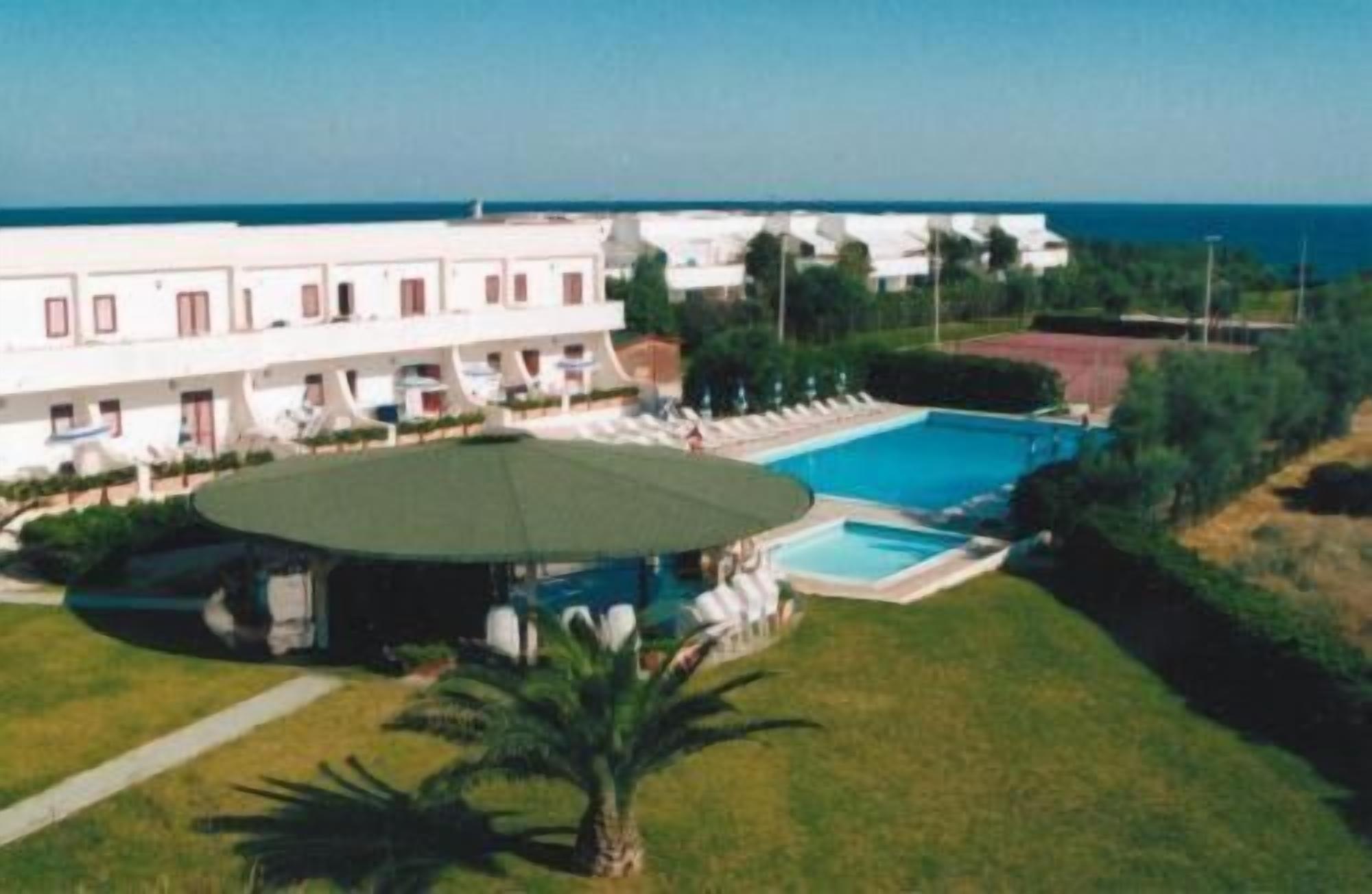 Ein Hotel mit Pool, überdachter Sitzgelegenheit und Meerblick.