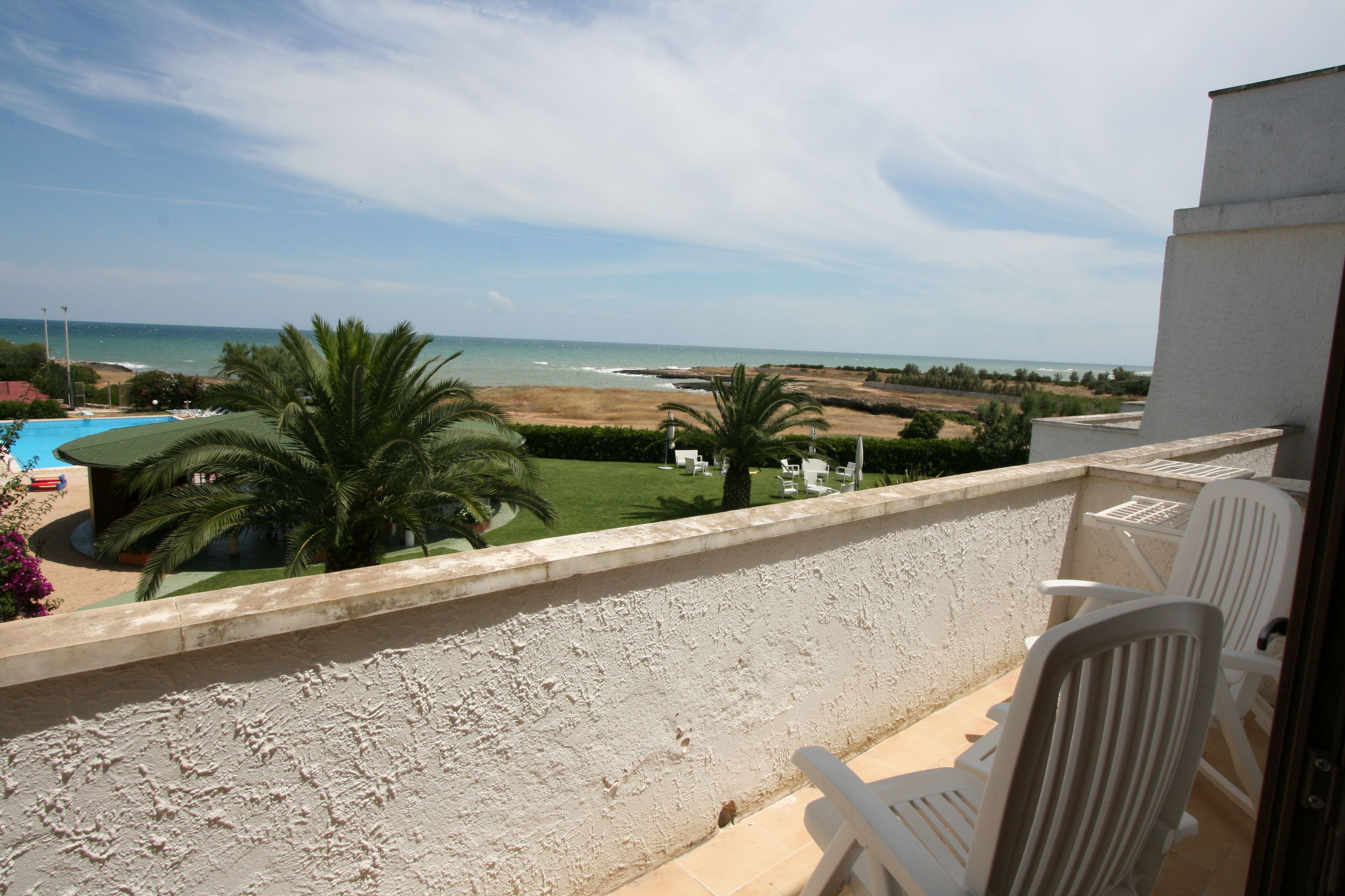 Ein Balkon mit Blick auf Strand und Meer.