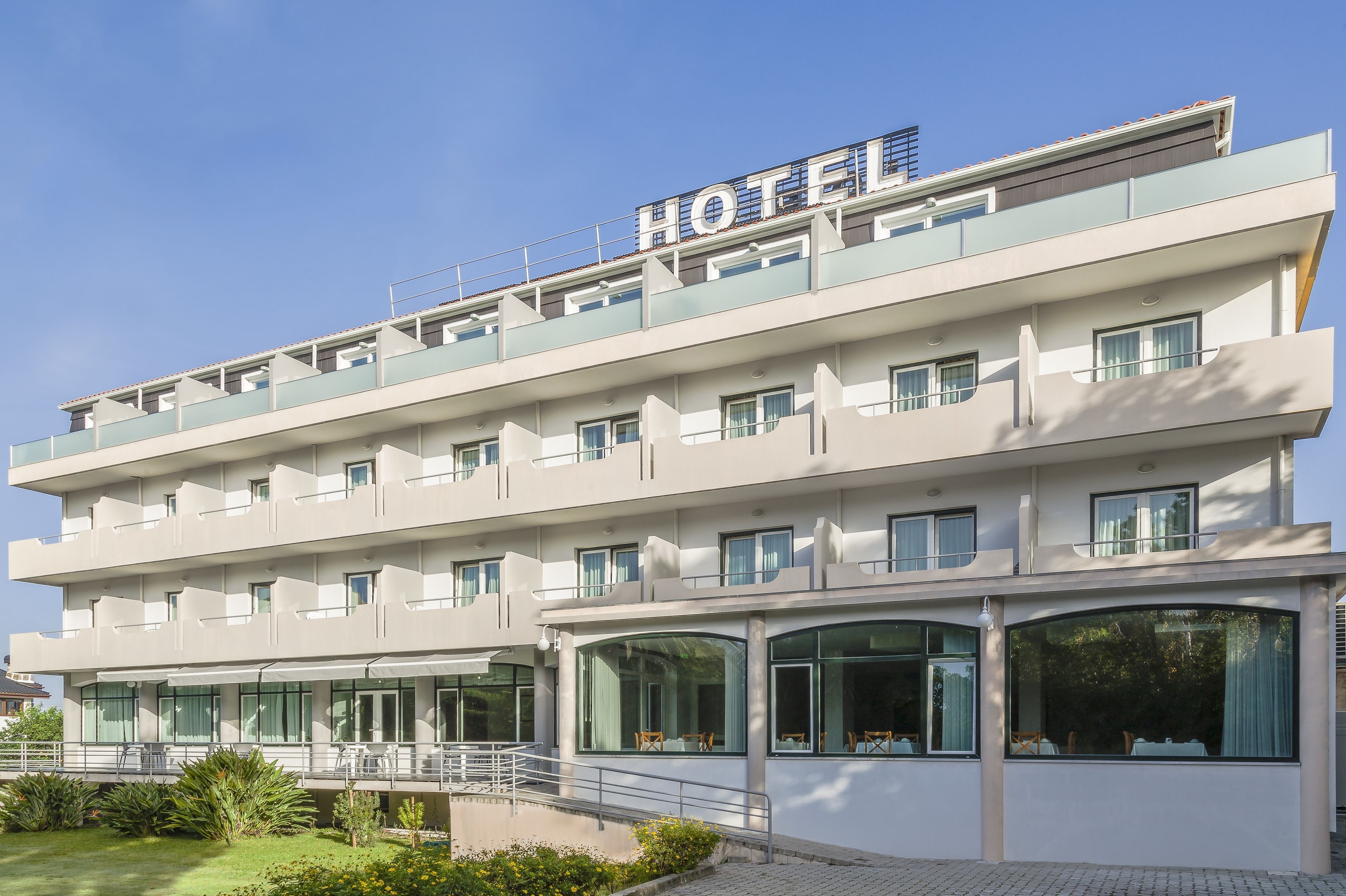 Um hotel com vários andares e um letreiro grande com a palavra 'HOTEL' no topo.