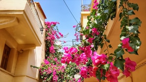 A narrow street with buildings on either side, some with balconies and others with ground-level entrances. - Iason Studios (Chania)