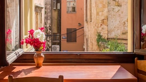 A view from a window with a vase of flowers on a wooden table. - Iason Studios (Chania)