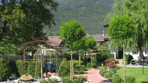 Ein Wohngebiet mit einem Pavillon, einem gepflasterten Weg und Häusern mit auffälligen Einfahrten.