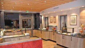 Eine moderne Hotelhalle mit Frühstücksbereich, Sitzgelegenheiten und Holzschnitzereien.